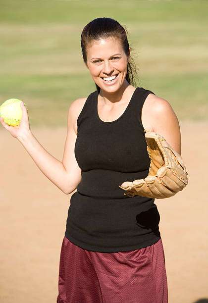 A female baseball glove hand catches a ball.
