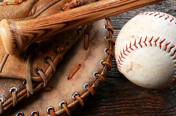 A top view image of an old used baseball, baseball glove, and baseball bat.