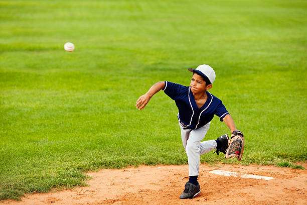 on a sunny field, one with a baseball glove and bat.