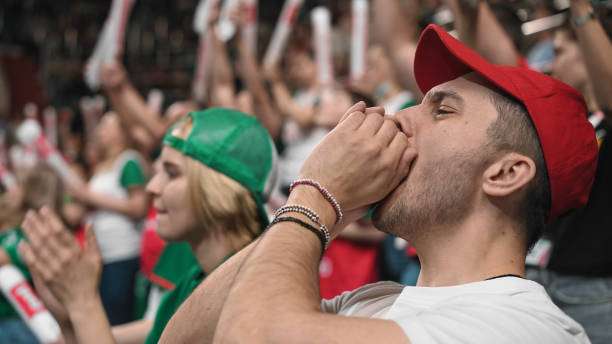 Cheering fan watches intense baseball game, anticipating great plays involving a baseball glove.