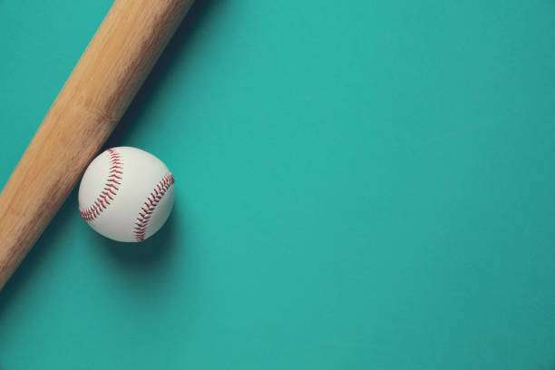 Baseball and bat on a teal surface, essential gear alongside a baseball glove.